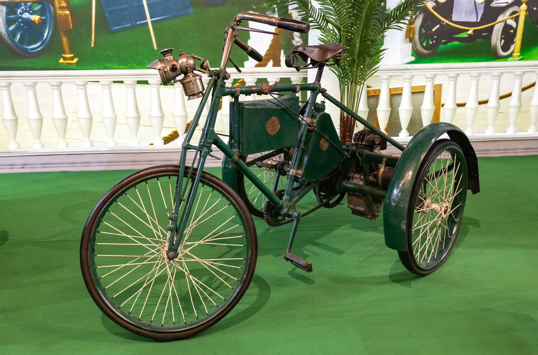 Этот моторный трицикл (трехколесный велосипед с мотором) немецкой фирмы Cudell в 1899 году завоевал золотую медаль на Международной выставке в Берлине. А потом оказался в гараже Николая II. Его мотор — это первый в мире быстроходный двигатель, он развивает до 2000 оборотов в минуту.