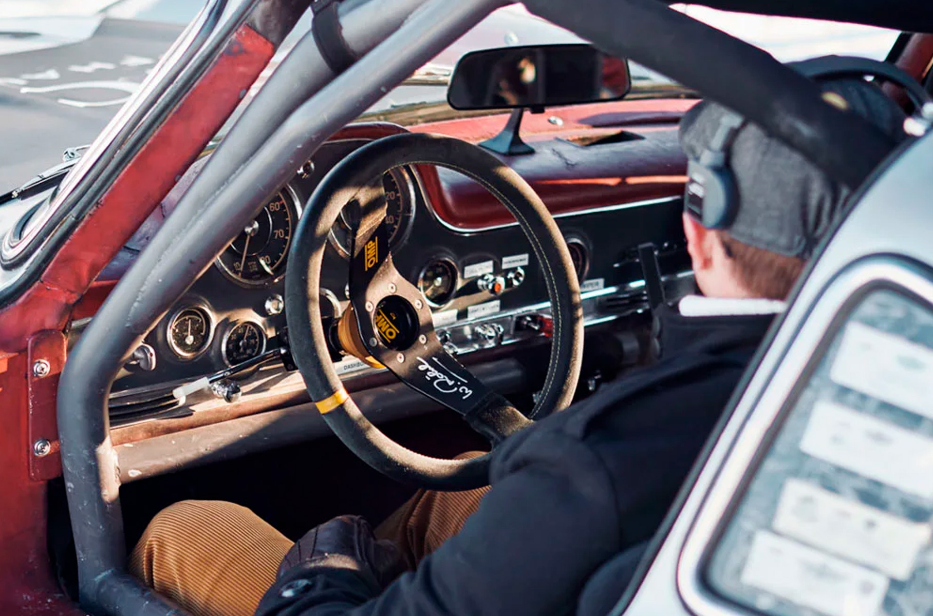 Да, состояние не назвать полностью аутентичным: тут стоят каркас безопасности, гоночный руль, современные ковши с пятиточечными ремнями. Но как же стильно все это сочетается с исторической патиной! Кстати, автограф на левой спице принадлежит еще одной легенде — Вальтеру Рёрлю.