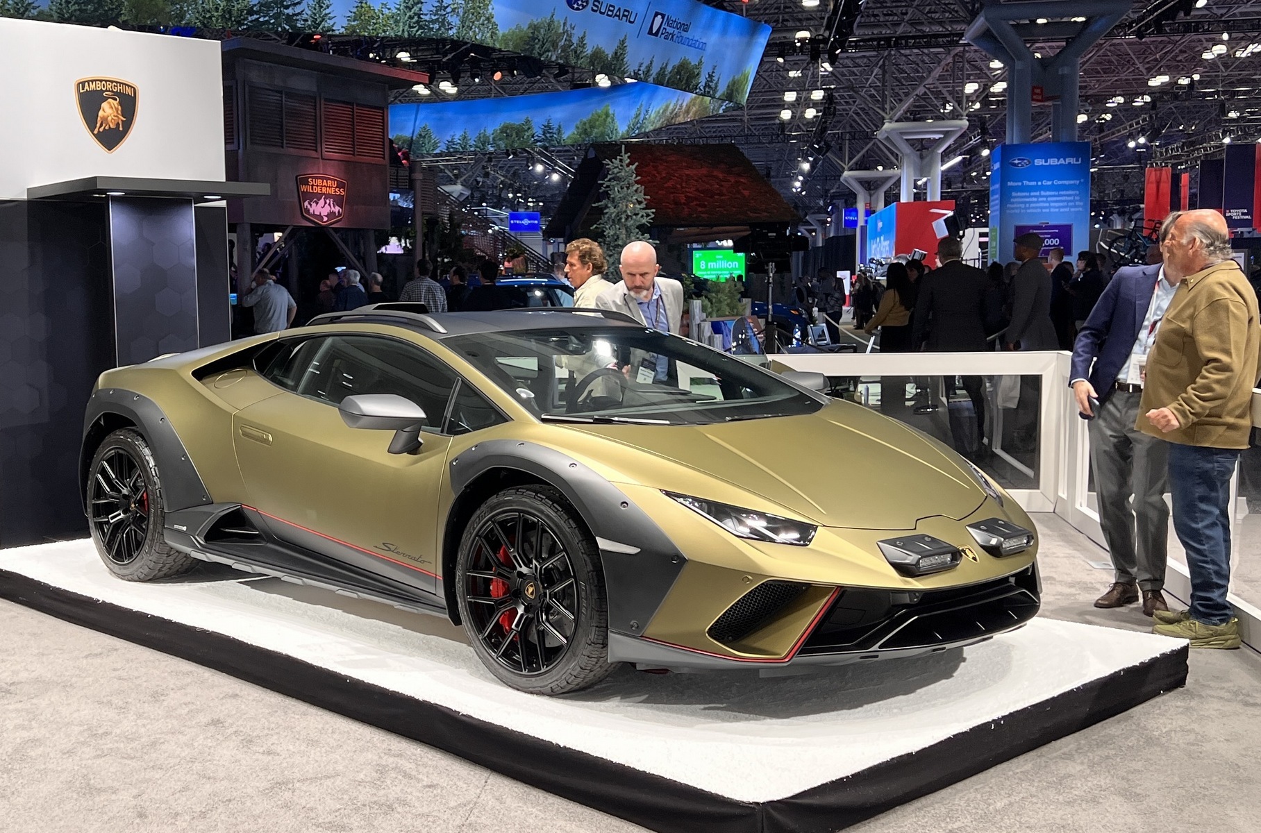 ### Lamborghini Huracán Sterrato Кажется, это первый публичный выход для [Lamborghini Huracán Sterrato](https://motor.ru/news/lamborghini-huracan-sterrato-30-11-2022.htm) — условно «внедорожной» модификации суперкара Huracán Evo. У него «атмосферник» V10 5.2, дефорсированный с 640 до 610 л.с., полный привод, приподнятый на 44 мм клиренс, особые настройки драйверской электроники... И, конечно, свой обвес во внедорожном духе с накладками из неокрашенного пластика, багажными рейлингами и дополнительными фарами.
