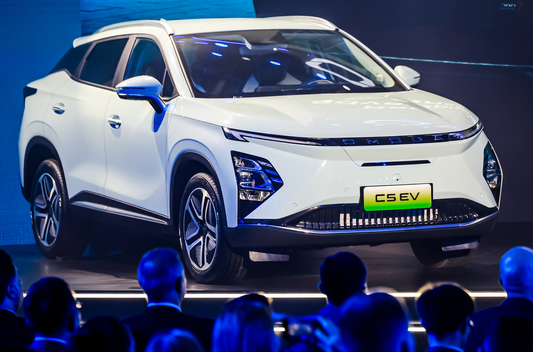 ### Omoda C5 e-QUA Бренд Omoda представил в Шанхае электрическую версию кроссовера [C5](https://motor.ru/lab/omoda-c5-video.htm). Внешне Omoda C5 e-QUA отличается глухим передним бампером без привычной решётки радиатора — есть лишь небольшой воздухозаборник понизу — и объединёнными в одну линию ходовыми огнями. Технических подробностей пока нет: известно, что единственный электромотор мощностью 224 л.с. вращает передние колёса, тяговая батарея емкостью 61 кВт·ч установлена под днищем. Запас хода на одной зарядке составляет 450 км.