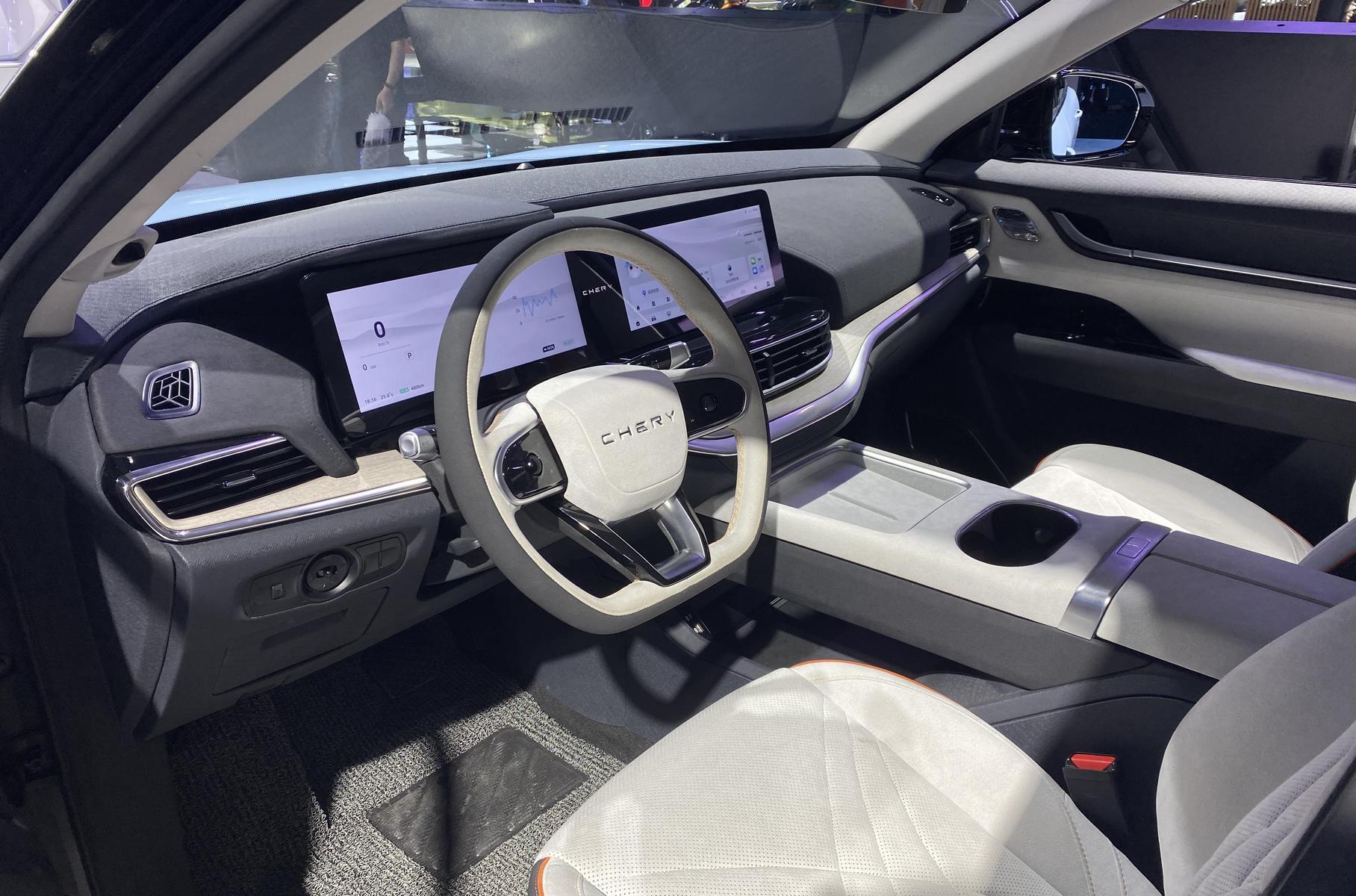 Внешность машины выполнена в новом фирменном стиле «digital super body», что бы это ни значило: у неё мягкие обводы, восходящая поясная линия и зачернёные крыша и стойки. «Двухэтажная» оптика напоминает новые Exeed Sterra, но никаких пиксельных панелей здесь нет: внизу просто установлены фары и воздухозаборники для охлаждения тормозов. Интерьер по нынешним временам выглядит довольно консервативно: передняя панель привычных очертаний, с козырьком над щитком приборов. Тем не менее, большой центральный дисплей физически выполнен заодно с виртуальным щитком. Физические кнопки внутри практически отсутствуют.