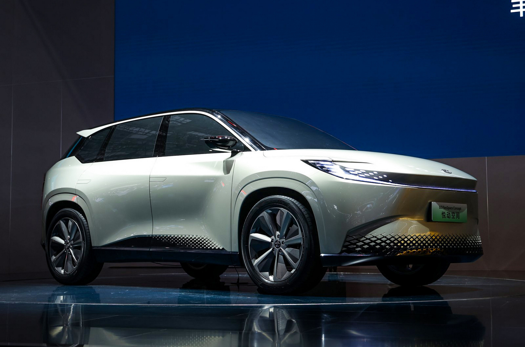 ### Toyota bZ FlexSpace Второй концепт-кар создавался в рамках другого СП с концерном GAC. Его внешность решена в том же дизайнерском языке: например, здесь похожие фары в виде C-образных скобок. Но внешность куда спокойнее, и это понятно: ведь перед нами типичный семейный кроссовер — возможно и семиместный, судя по размерам. Судя по рендерам, интерьер очень похож на bZ Sport, но выполнен в более спокойной цветовой гамме. Обе машины должны стать серийными в 2024 году, но пока зрителям показали лишь макеты без открывающихся дверей, с наглухо затонированными стёклами.
