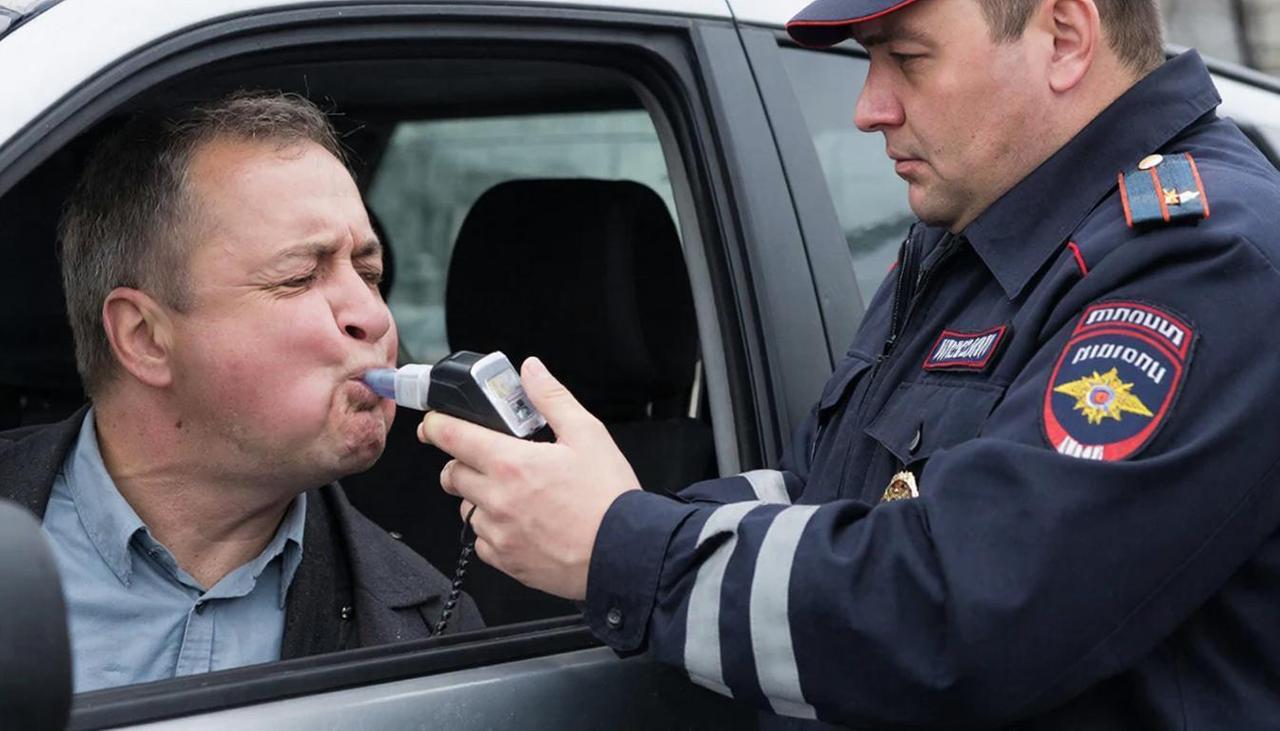 Инспектор ГИБДД продувает водителя на алкогольное опьянение
