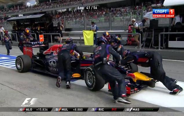 Механики толкают болид Риккардо по пит-лейну