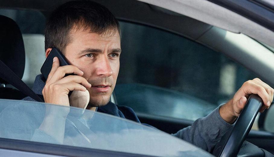 Водитель за рулем с телефоном